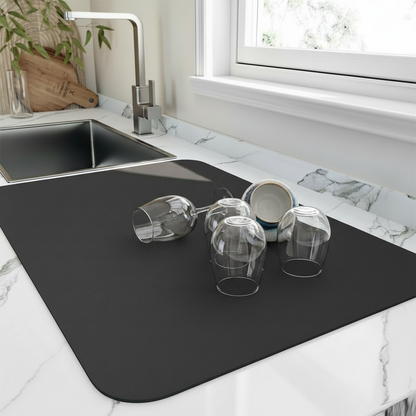 Diatomite quick-dry dish mat in use beside the kitchen sink with glasses drying