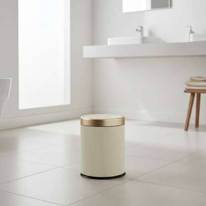 Luxury oval press-top trash can with gold lid styled in a modern bathroom - Nerora