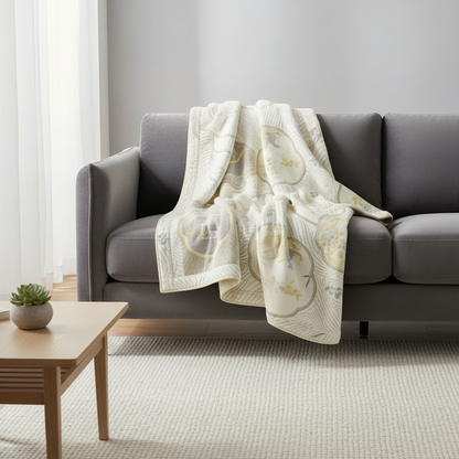 Reversible Coastal Dreams Blanket draped over a sofa in a bright living room